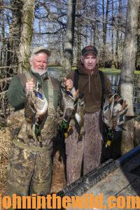 Two hunter pose with their downed ducks