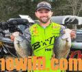An angler proudly shows off two crappie