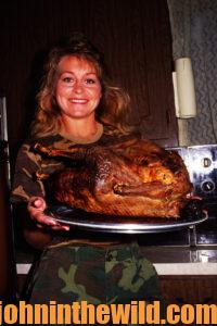 A proud chef shows off her cooked turkey