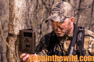 A hunter inspecting his trail camera