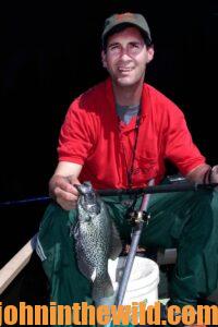 Fisherman poses with a crappie he caught at night