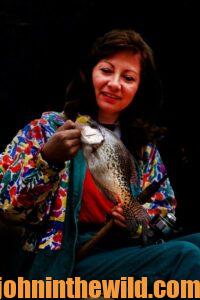 Woman poses with crappie while nighttime fishing