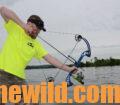 A bowfisherman aims his bow