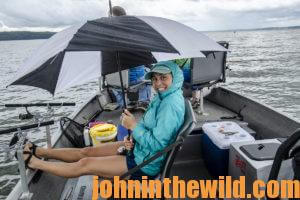 Abbey tries to avoid some of the rain on the boat with her rain jacket and umbrella