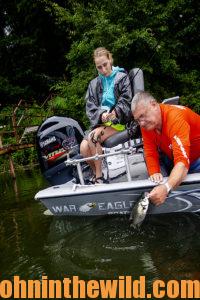 Two anglers work together to pull in a fish