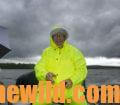 John E. Phillips tries to avoid the rain smiling in his rain jacket