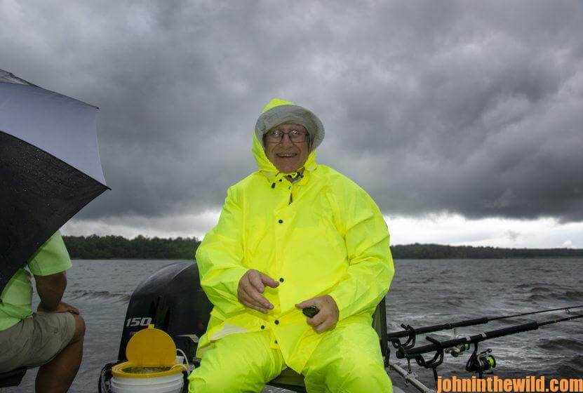 John E. Phillips tries to avoid the rain smiling in his rain jacket