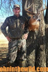 A hunter poses with a buck
