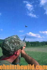 A hunter aims at a bird