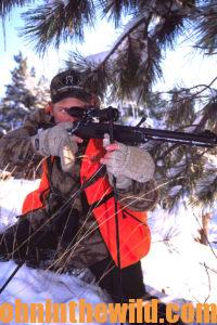 A hunter aims with his rifle