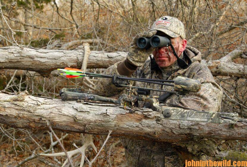 A hunter scouts out the area with binoculars