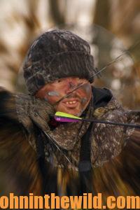 A hunter aims with his bow