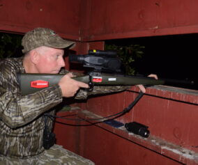 A hunter patiently waits in a blind for a shot at taking a wild pig