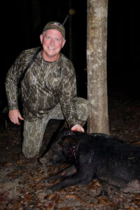 A hunter with his downed hog