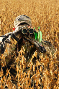 A hunter looks through his binoculars