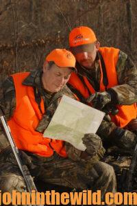 Two hunters consult a map of the area