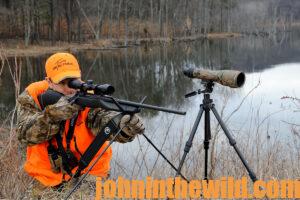 A hunter looks through a scope 