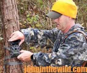 A hunter checks his trail camera