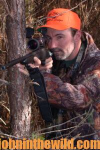 A hunter aims his rifle