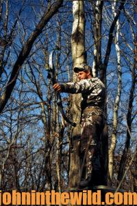A hunter aims his bow
