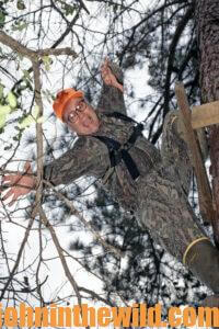 A hunter mimics a fall from a tree stand showing the importance of a safety harness