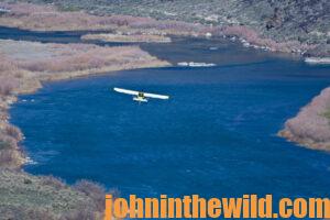 Yellow and White Airplane Flying Through the Canyona body of water