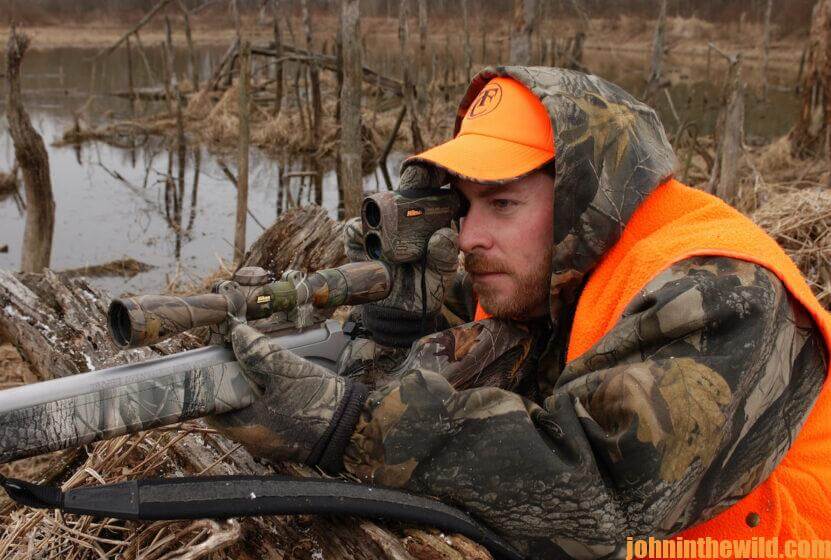 A hunter looks through the scope of his rifle