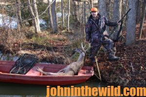 A hunter retrieves his downed deer in a boat