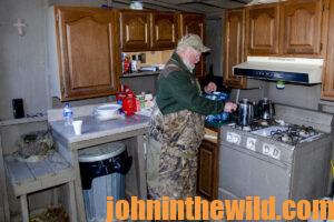 A hunter prepares a meal in the kitchen