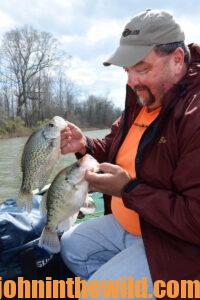 A fisherman inspects his two crappie