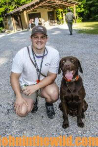 A hunter and his dog smile for a photo