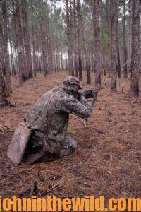 A hunter aims his rifle