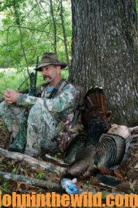 A hunter sits next to his downed turkey