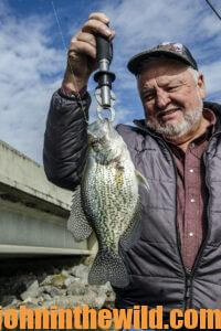 An angler holds up his crappie