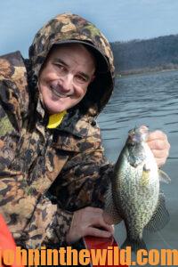 An angler smiles holding his crappie