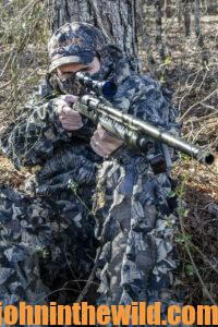 A hunter aims his rifle as he waits for a turkey to come into range