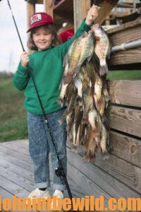 An angler holds a large catch of crappie