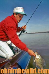 A fisherman pulls in a crappie