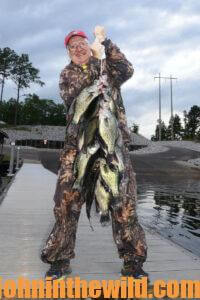 An angler holds up a large catch of crappie