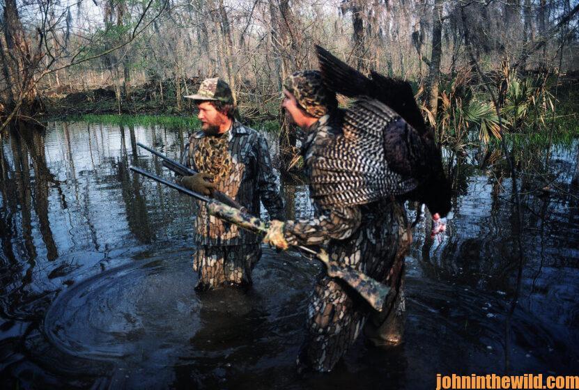 Two turkey hunters wade in a creek