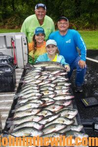 A group of anglers smiles with the fish they caught