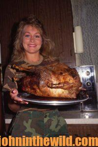 A smiling chef shows off her cooked turkey