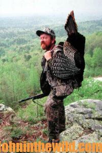 A hunter carries his downed gobbler