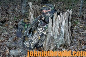 A hunter waits camouflaged for a gobbler to approach 