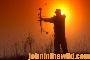 Elk hunter, Eddie Salter, preparing to shoot his bow and arrow at sunset.