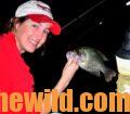 Woman poses with a crappie she caught while nighttime fishing