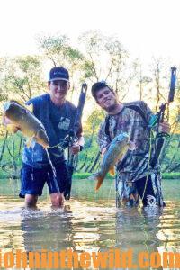 Two bowfishermen show off their fish