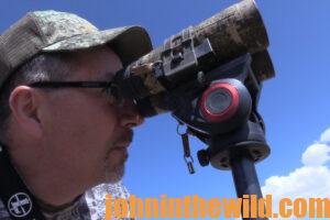 A hunter looks through his binoculars