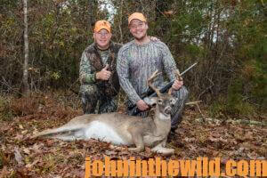 Two hunters pose with their downed deer