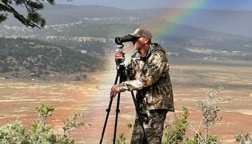 Hunting photographer with a rainbow background